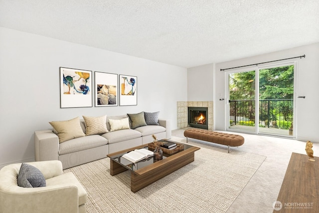 carpeted living room featuring a tiled fireplace and a textured ceiling