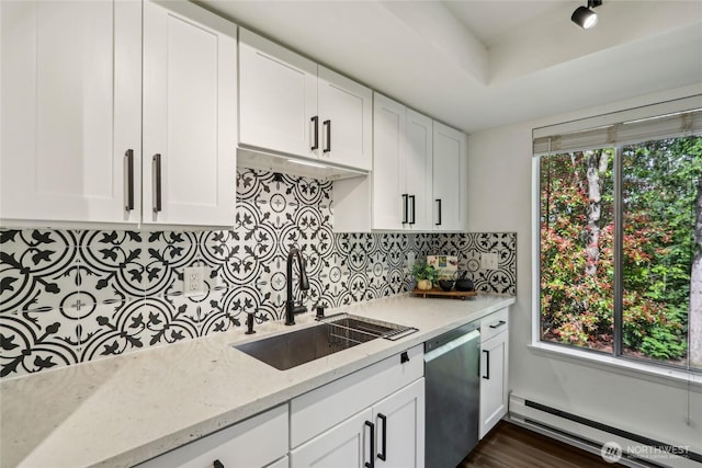 kitchen featuring a baseboard heating unit, stainless steel dishwasher, a sink, and plenty of natural light
