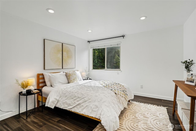 bedroom with dark wood finished floors, baseboards, and recessed lighting