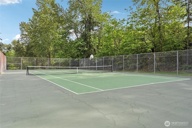view of tennis court with fence and community basketball court