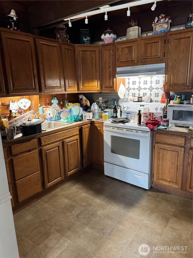 28103 Q St, Ocean Park, WA 98640 - kitchen featuring under cabinet range hood, brown cabinets, light countertops, and electric stove