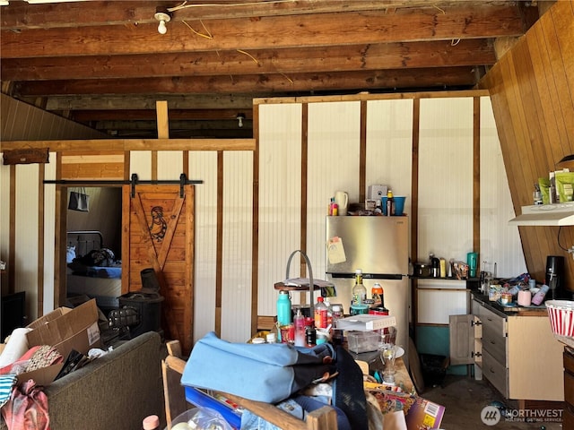 28103 Q St, Ocean Park, WA 98640 - interior space featuring freestanding refrigerator, wooden walls, carpet flooring, and a barn door