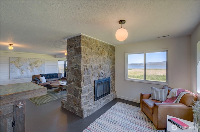 15410 Sandridge Rd, Long Beach, WA 98631 - living area with a textured ceiling, a stone fireplace, and a water view