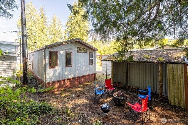 rear view of property with a fire pit
