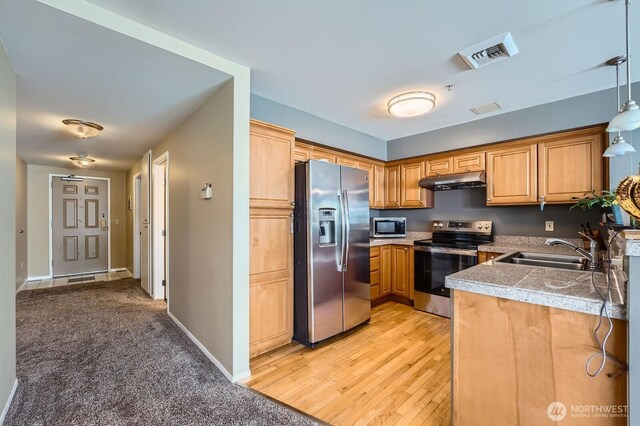 3201 Pacific Ave Unit 305, Tacoma, WA 98418 - kitchen with appliances with stainless steel finishes, a sink, tile counters, under cabinet range hood, and pendant lighting