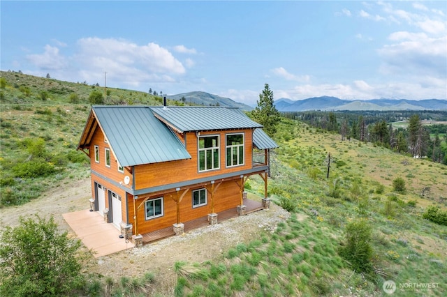 41 Red Tail Ridge Rd, Twisp, WA 98856 - back of house featuring a mountain view, a garage, driveway, and metal roof