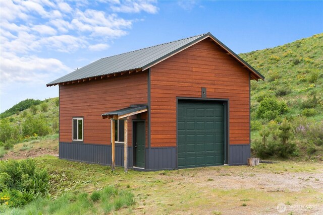 41 Red Tail Ridge Rd, Twisp, WA 98856 - view of side of home with an outdoor structure, a garage, metal roof, and a mountain view