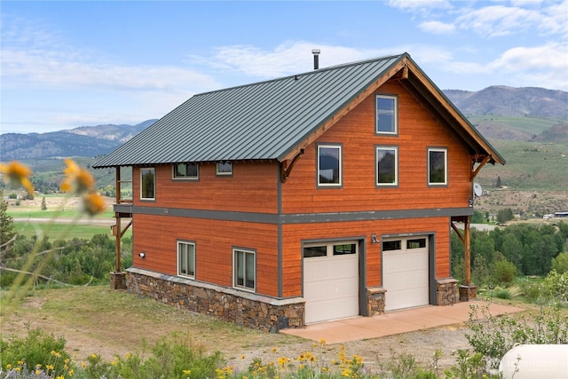 41 Red Tail Ridge Rd, Twisp, WA 98856 - view of property exterior with a standing seam roof, a mountain view, a garage, and stone siding