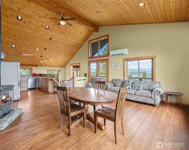 41 Red Tail Ridge Rd, Twisp, WA 98856 - dining room featuring a wood stove, an AC wall unit, light wood-style flooring, a ceiling fan, and wooden ceiling