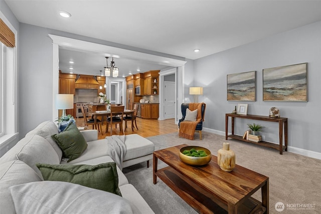 living room featuring recessed lighting, baseboards, and light carpet