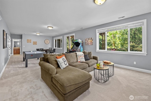 living room with light colored carpet, baseboards, and plenty of natural light
