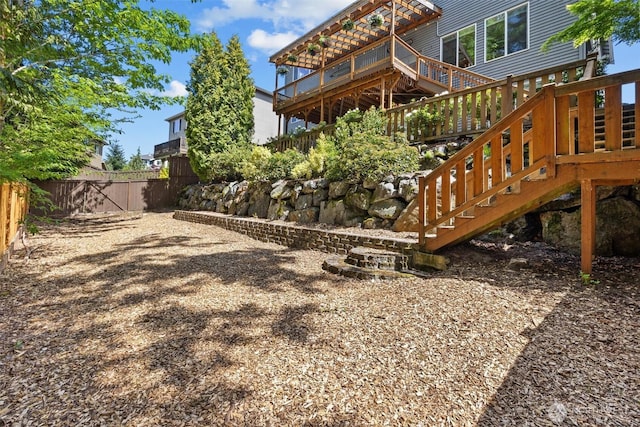 fenced backyard with stairway and a wooden deck