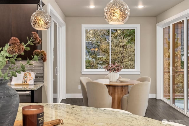 dining room with baseboards, dark wood-style flooring, and a healthy amount of sunlight