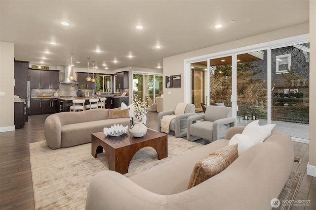 living area with dark wood-style floors and recessed lighting