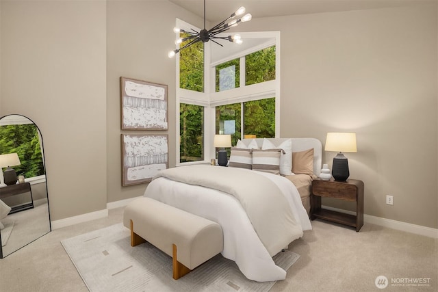 bedroom with light carpet, baseboards, a high ceiling, and a notable chandelier