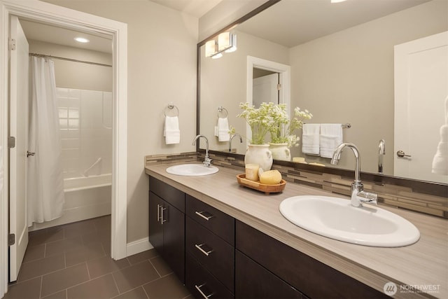 full bathroom featuring double vanity, tile patterned flooring, baseboards, and a sink