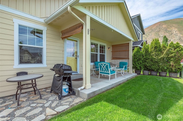 view of patio with a mountain view, grilling area, and covered porch