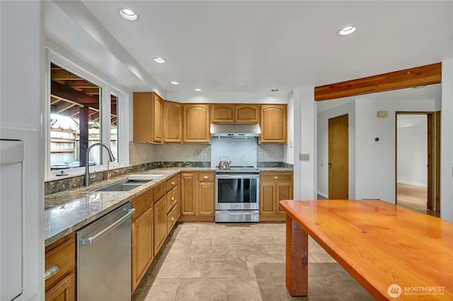 1002 30th St NE, Auburn, WA 98002 - kitchen with stainless steel appliances, under cabinet range hood, light stone countertops, a sink, and backsplash