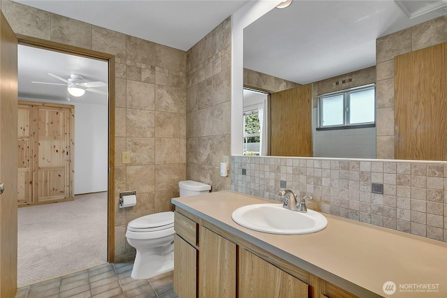 1002 30th St NE, Auburn, WA 98002 - bathroom with tile walls, toilet, tile patterned flooring, a ceiling fan, and vanity