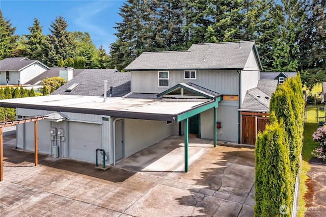 1002 30th St NE, Auburn, WA 98002 - rear view of property with roof with shingles, a carport, a garage, and driveway