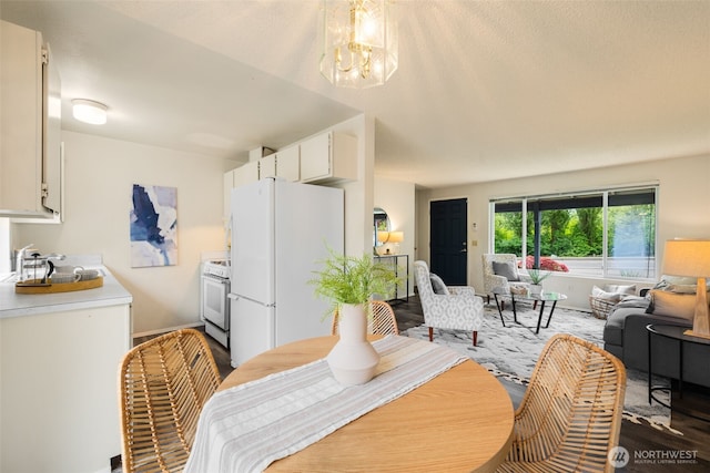 dining area with wood finished floors, a chandelier, and baseboards
