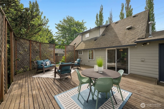 wooden deck with an outdoor living space and fence