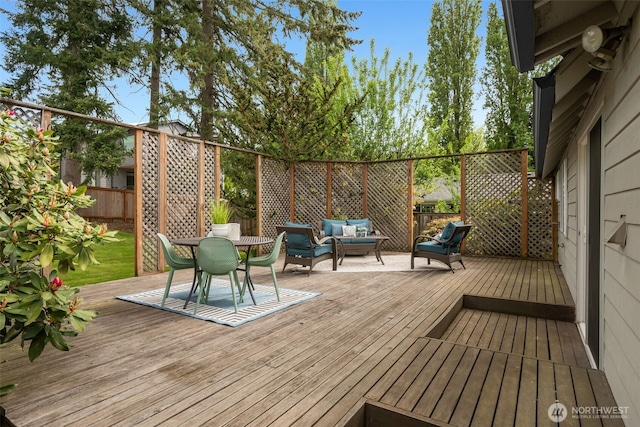 wooden terrace featuring an outdoor living space and fence