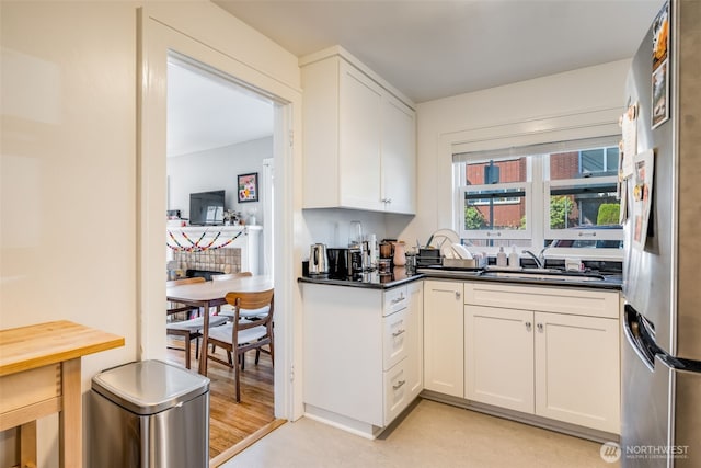 746 10th Ave E, Seattle, WA 98102 - kitchen featuring freestanding refrigerator, dark countertops, white cabinets, and a sink