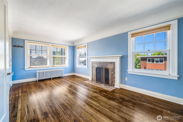 746 10th Ave E, Seattle, WA 98102 - unfurnished living room featuring radiator, baseboards, a tiled fireplace, and wood finished floors
