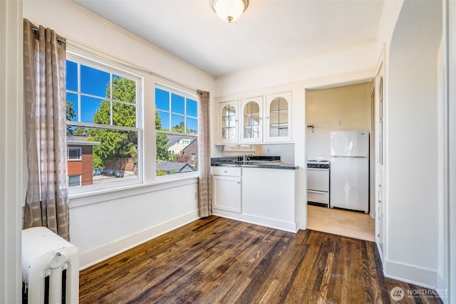 746 10th Ave E, Seattle, WA 98102 - kitchen with white cabinetry, white appliances, glass insert cabinets, and dark wood-type flooring