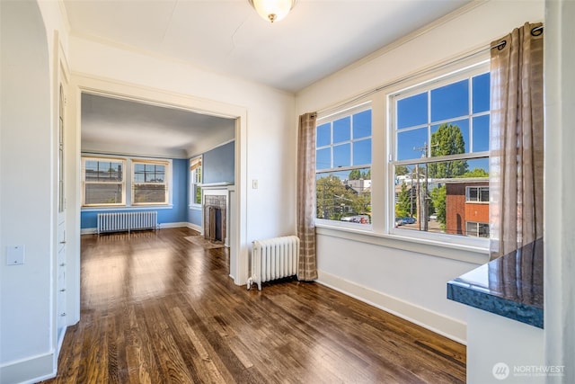 746 10th Ave E, Seattle, WA 98102 - unfurnished living room with dark wood-style flooring, baseboards, and radiator heating unit