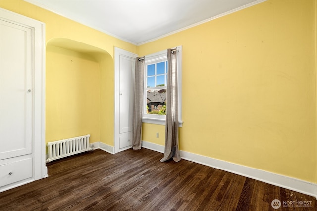 746 10th Ave E, Seattle, WA 98102 - spare room featuring baseboards, ornamental molding, radiator heating unit, and dark wood finished floors