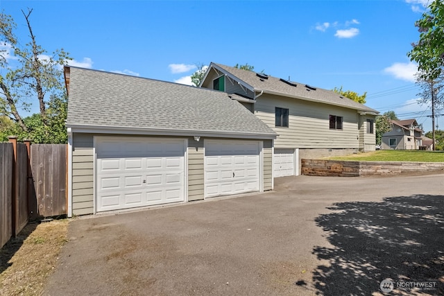 4822 S M St, Tacoma, WA 98408 - view of home's exterior featuring fence, asphalt driveway, a shingled roof, and a garage