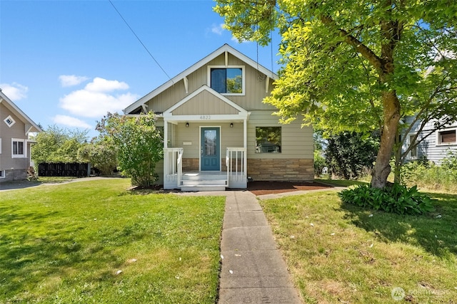 4822 S M St, Tacoma, WA 98408 - view of front of house with board and batten siding, stone siding, and a front lawn