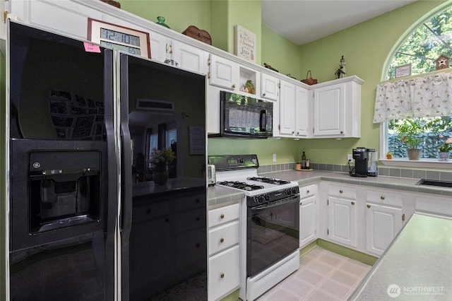 kitchen featuring white cabinetry, plenty of natural light, and black appliances