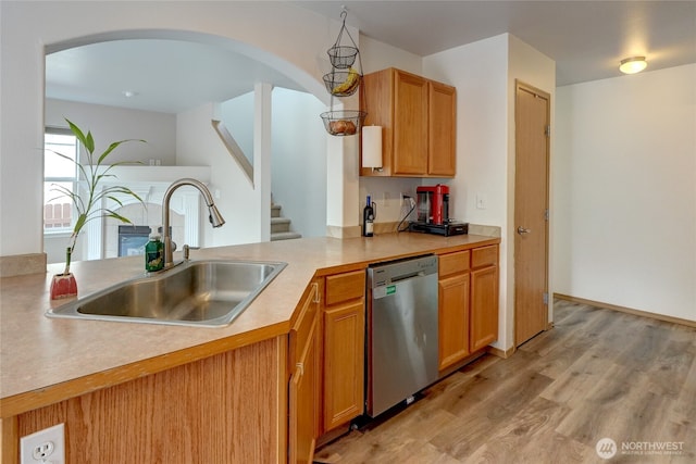 2824 187th St E, Tacoma, WA 98445 - kitchen with dishwasher, a sink, light countertops, light wood finished floors, and arched walkways