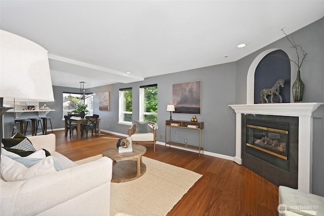 living room featuring wood finished floors, a fireplace, baseboards, recessed lighting, and beamed ceiling