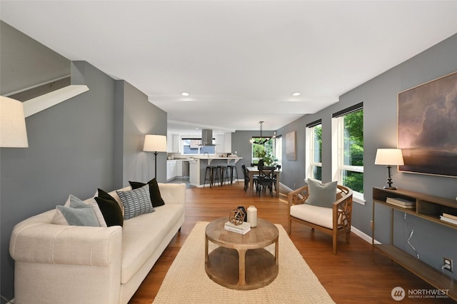 living room with dark wood-style flooring, baseboards, a chandelier, and recessed lighting