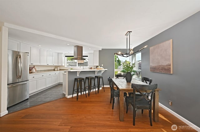 dining space featuring a chandelier, dark wood-type flooring, healthy amount of natural light, baseboards, and recessed lighting