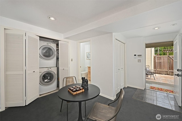 laundry area featuring stacked washer / drying machine, baseboards, and recessed lighting