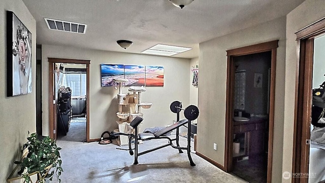 exercise area with carpet, visible vents, and baseboards