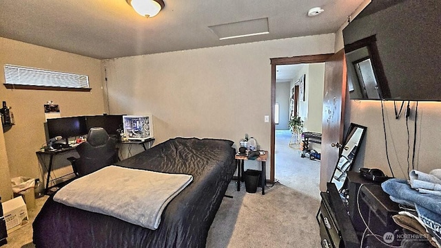 bedroom featuring light carpet and attic access
