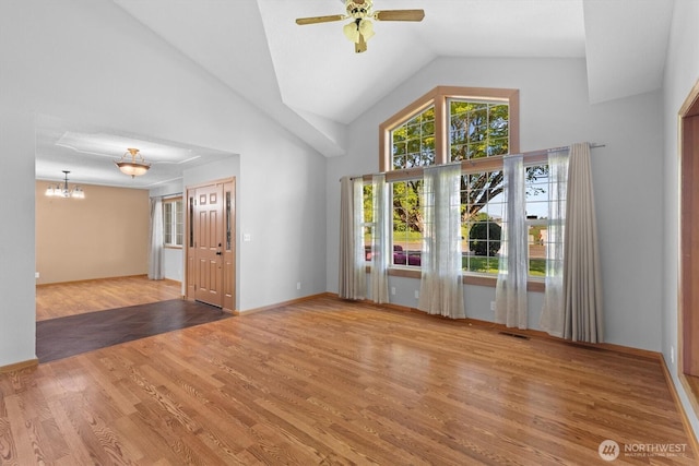2350 38th Ave, Longview, WA 98632 - unfurnished living room featuring a ceiling fan, high vaulted ceiling, wood finished floors, a chandelier, and baseboards