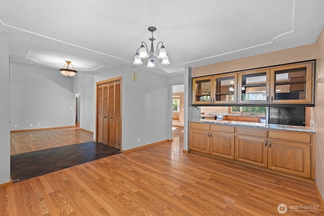 2350 38th Ave, Longview, WA 98632 - kitchen with light wood-type flooring, a textured ceiling, glass insert cabinets, a chandelier, and baseboards