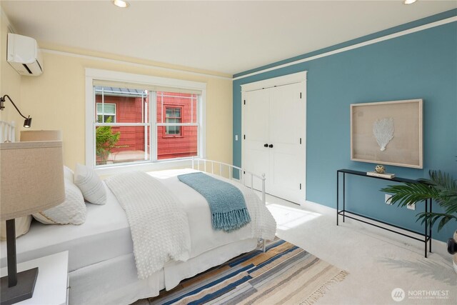 bedroom with an AC wall unit, recessed lighting, and a closet