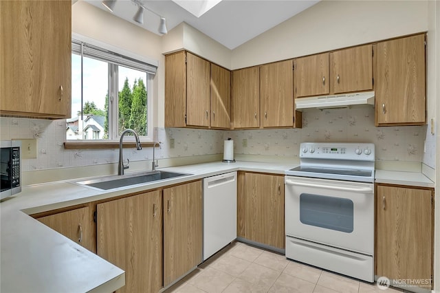 1004 30th St NE, Auburn, WA 98002 - kitchen featuring white appliances, under cabinet range hood, a sink, light countertops, and backsplash