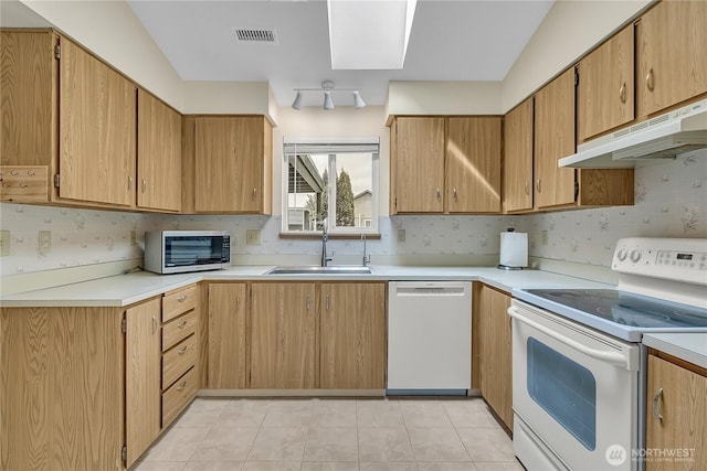 1004 30th St NE, Auburn, WA 98002 - kitchen with white appliances, a sink, under cabinet range hood, and light countertops