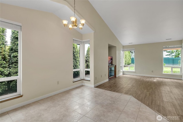 1004 30th St NE, Auburn, WA 98002 - unfurnished room featuring a chandelier, lofted ceiling, tile patterned floors, and baseboards