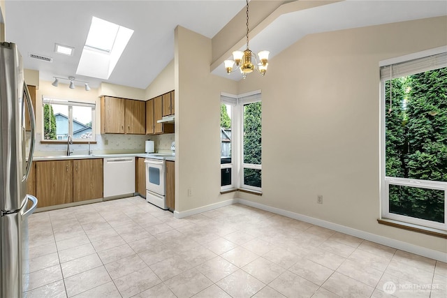 1004 30th St NE, Auburn, WA 98002 - kitchen with white appliances, light countertops, a skylight, lofted ceiling, and light tile patterned floors