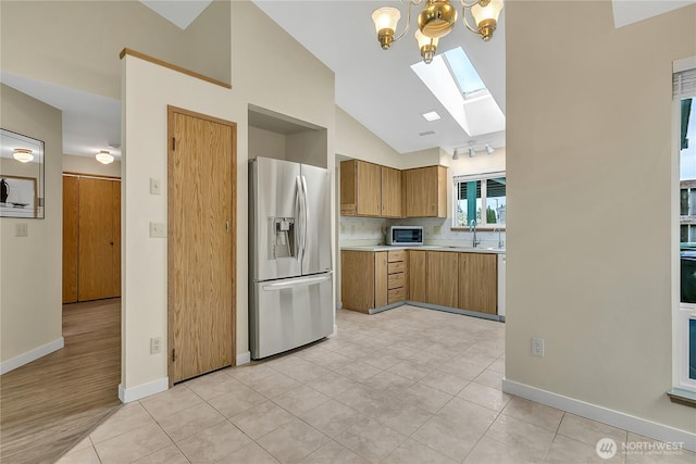 1004 30th St NE, Auburn, WA 98002 - kitchen with stainless steel appliances, a skylight, light countertops, high vaulted ceiling, and a chandelier
